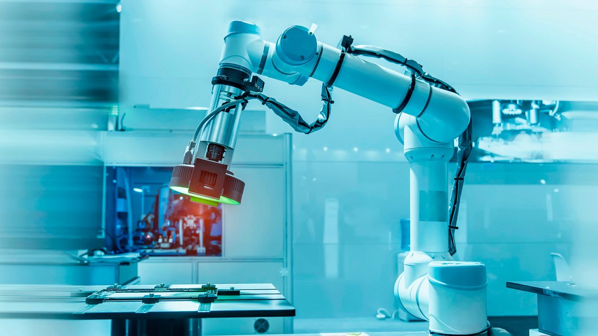 A white industrial robotic arm operates over a conveyor in a high-tech manufacturing environment. 