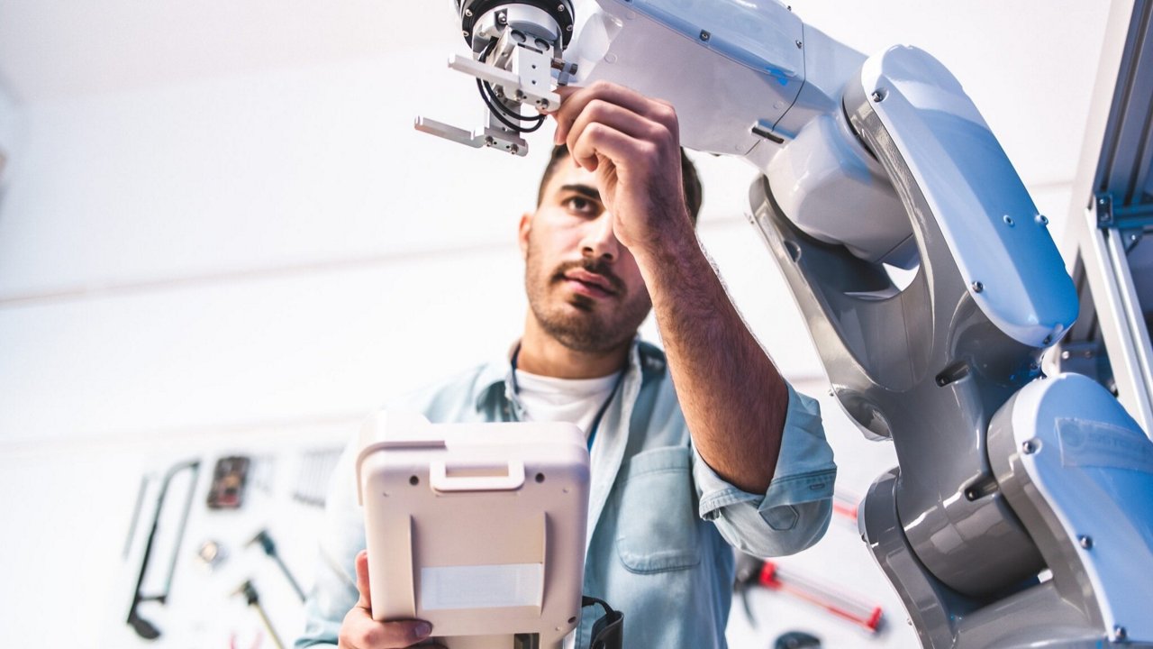 A person interacts with a robotic arm in a modern laboratory setting