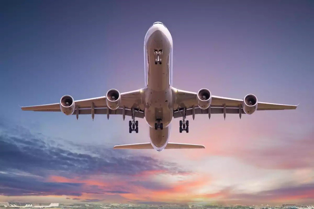 활기찬 석양 하늘을 배경으로 비행 중 포착된 대형 상업용 비행기.