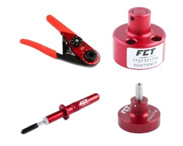 A collection of red tools featuring the FCT logo and visible text such as '1731121734' and 'POSITIONER'. The tools include a clamp with red handles, a cylindrical component, and other precision instruments. The image highlights the metallic finish and functional design of the tools.