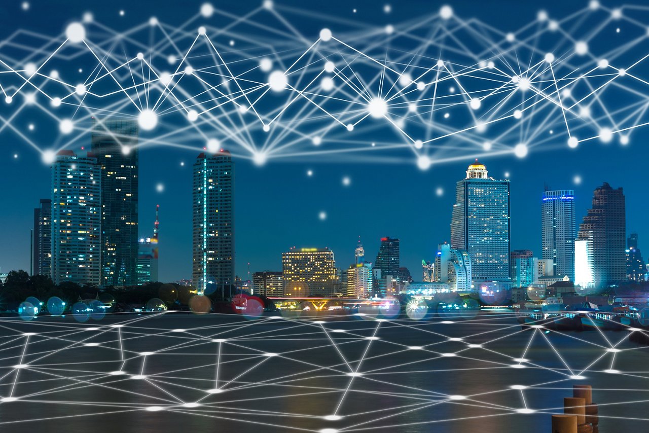 A glowing cityscape at night with a digital network overlay, symbolizing urban connectivity and innovation