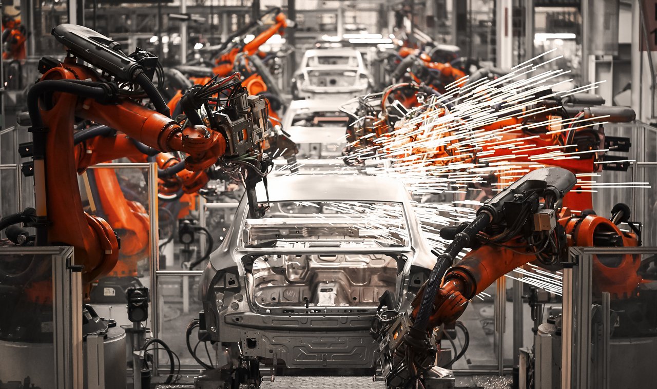 An industrial automotive assembly line featuring robotic arms welding car frames