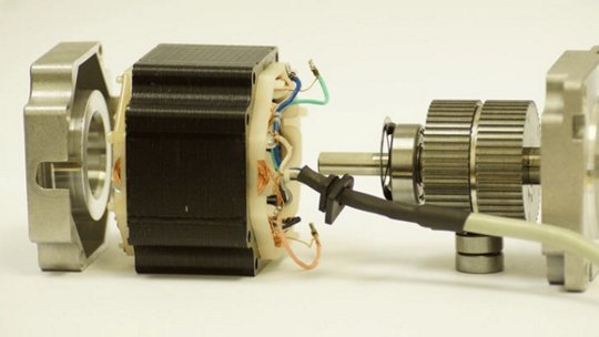 A close-up view of a disassembled stepper motor showcasing its internal components, including wiring and gears