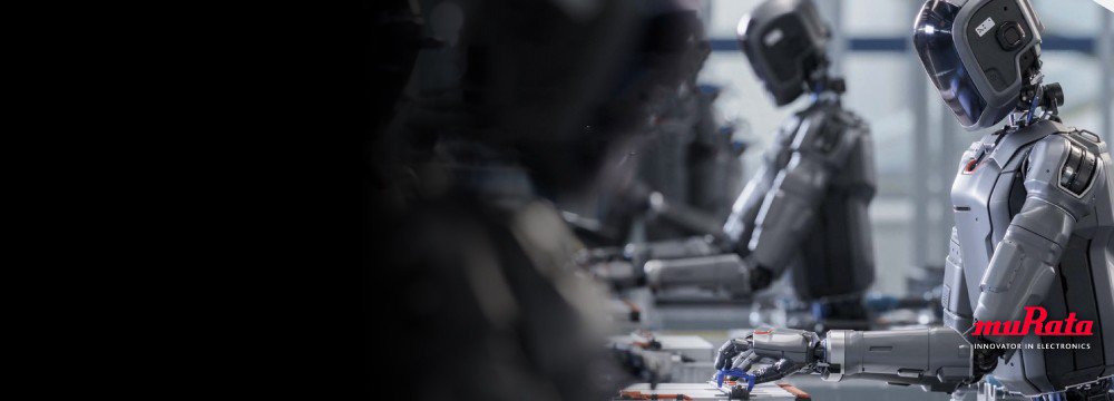 A row of humanoid robots is seated at a workstation assembling small electronic components