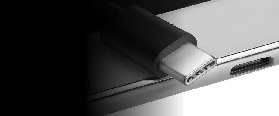 Close-up of a USB Type-C connector partially inserted into a sleek metallic device port.