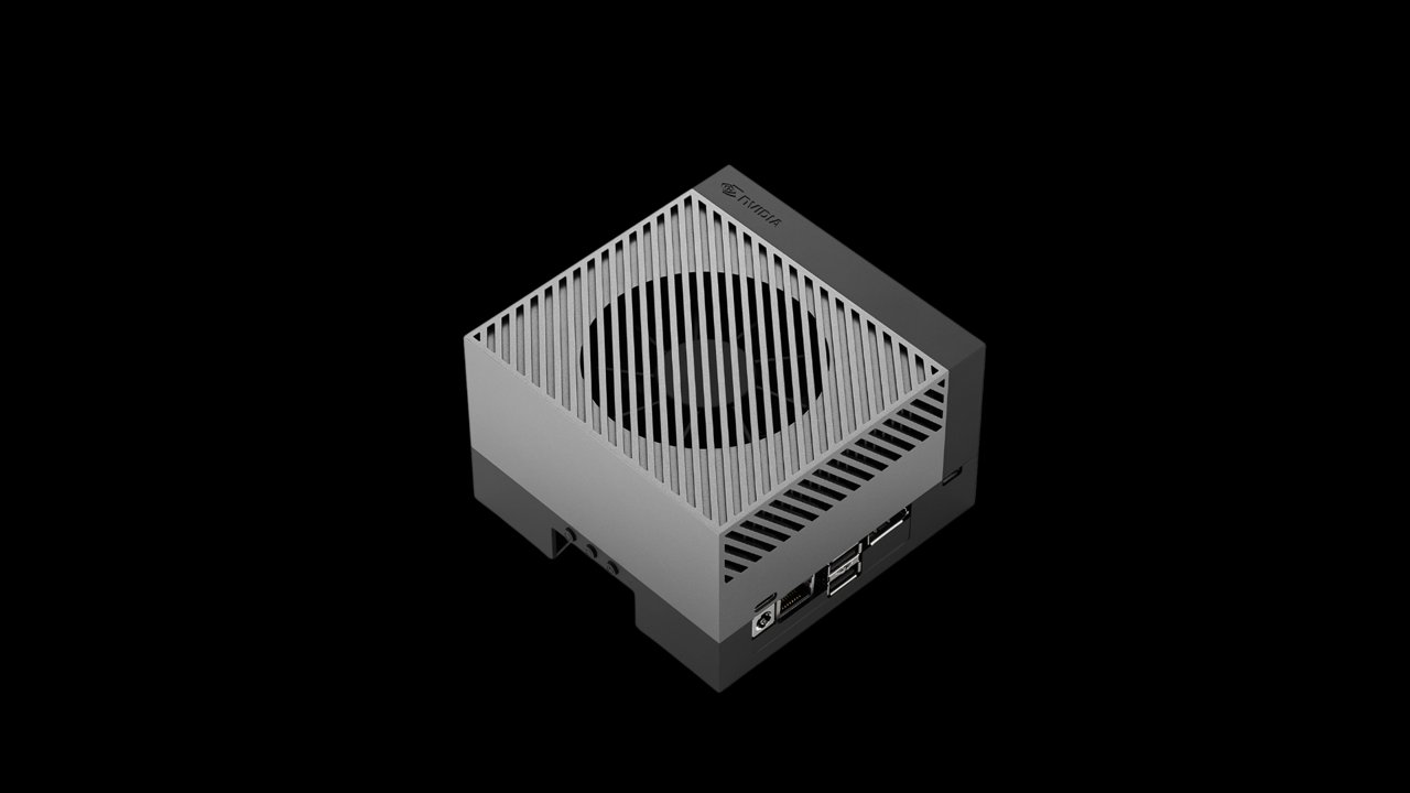 A compact mini computer in a sleek, vented metal enclosure is displayed against a solid black background.