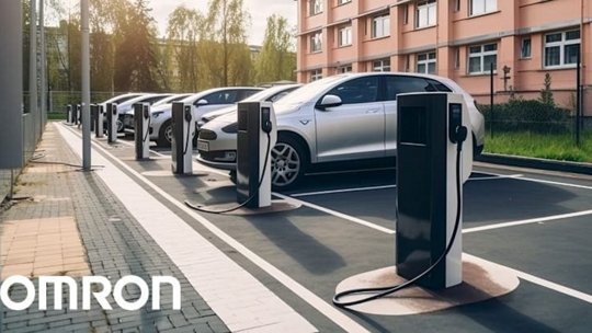 A row of electric vehicles parked at a modern charging station in an urban setting