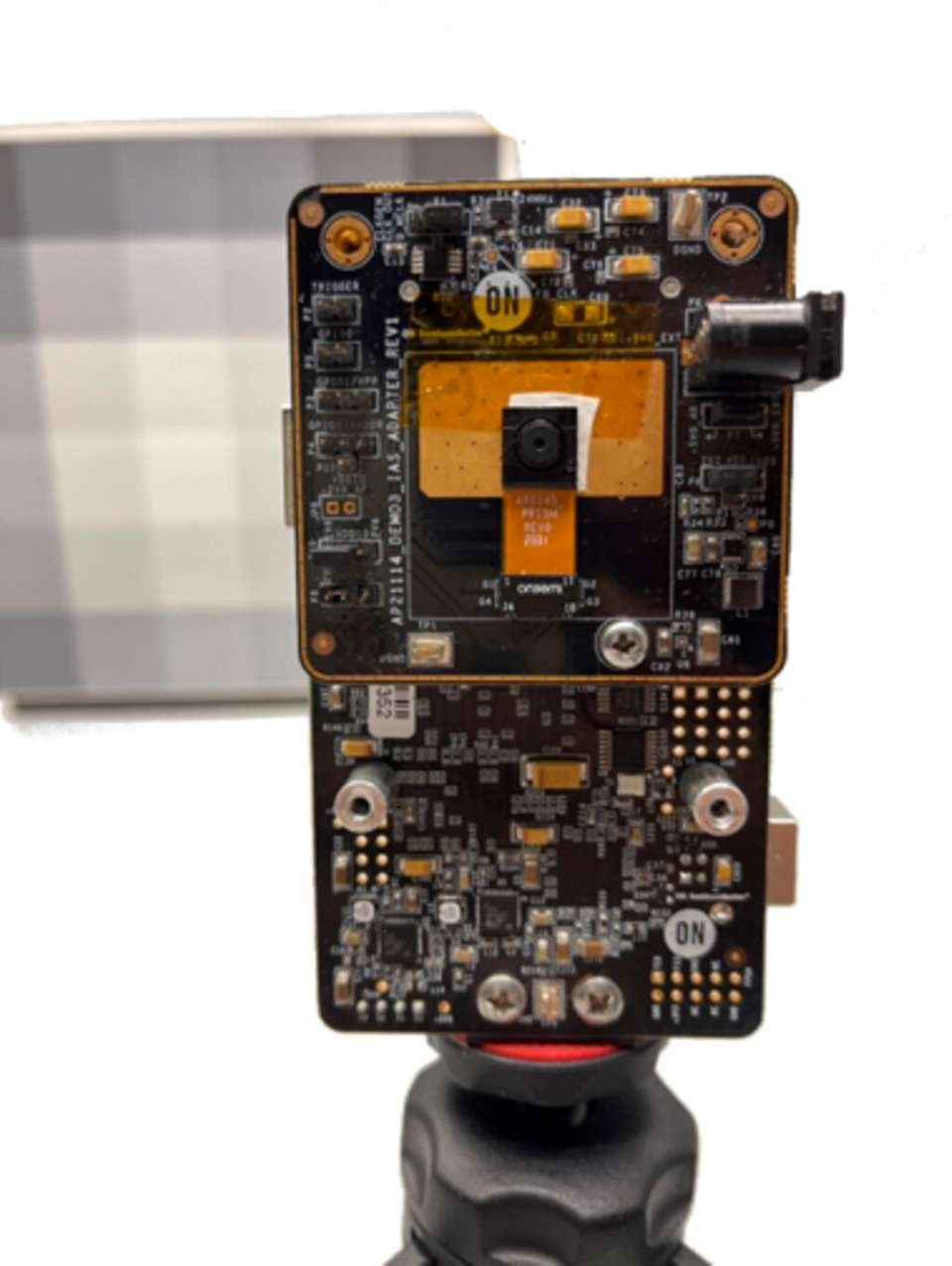 A close-up view of a custom-built circuit board featuring a mounted camera module