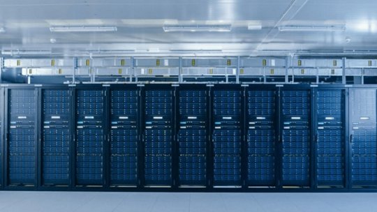Un ampio data center all'avanguardia con file di rack server con luci LED blu