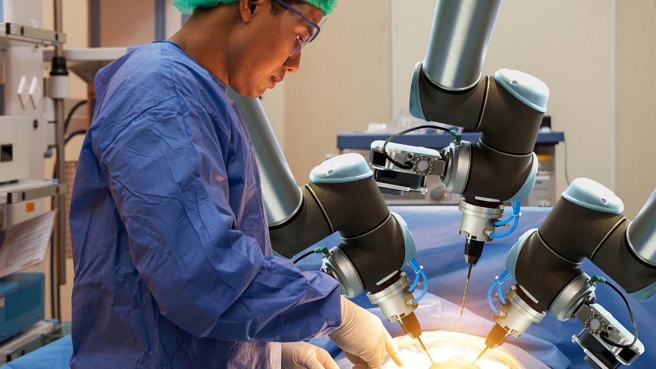 A medical professional operates a robotic surgical system in a clinical setting.