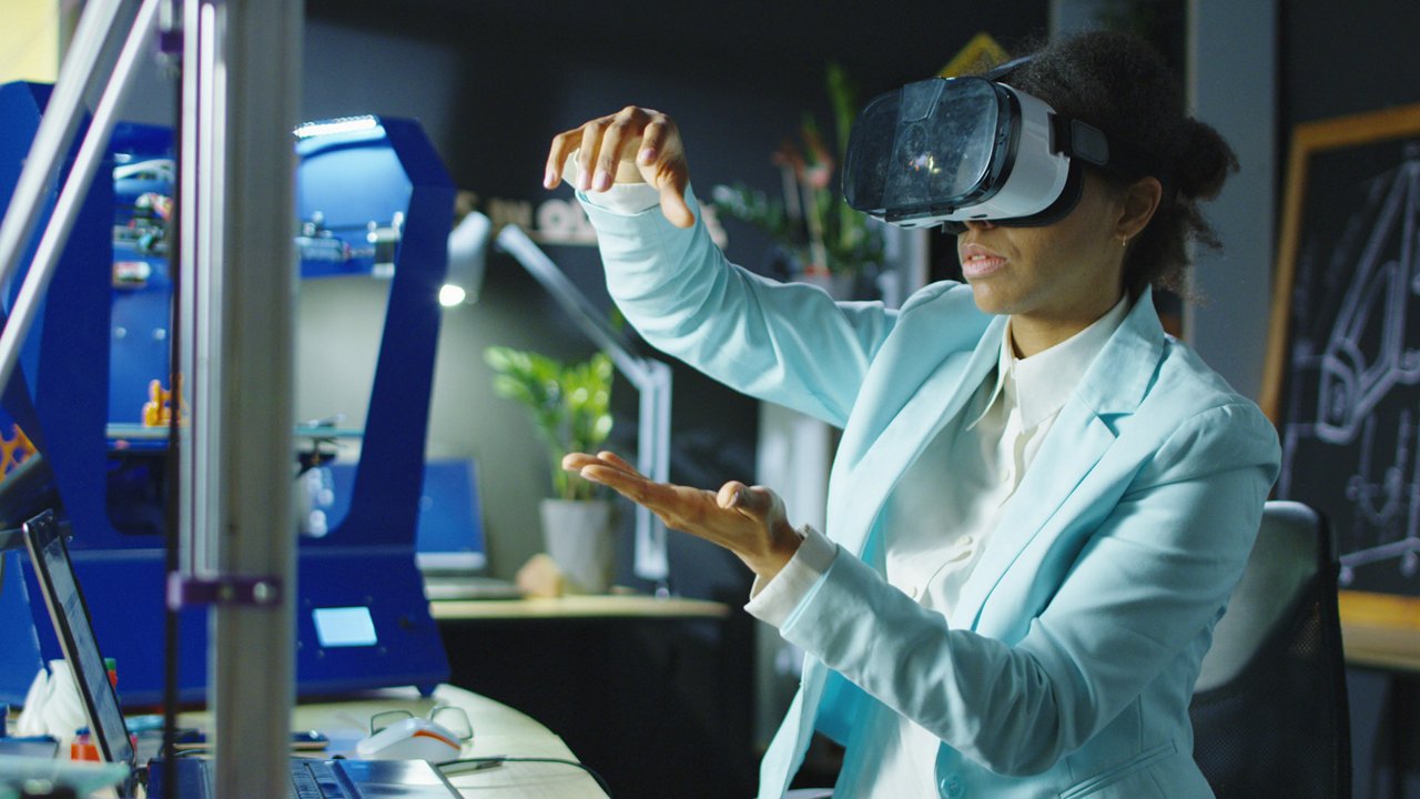 A professional wearing a virtual reality headset interacts with a simulated environment in a modern technology lab.