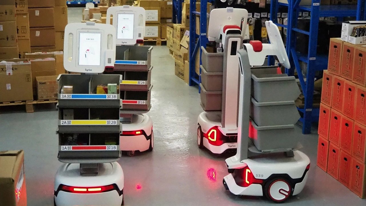 Autonomous robots equipped with storage bins operate in a warehouse setting. 
