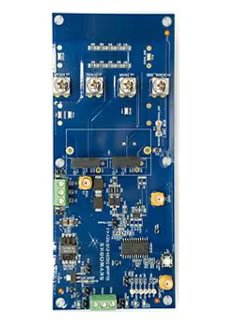 A blue printed circuit board is shown with various electronic components, connectors, and adjustment dials. The board features visible microchips, resistors, and capacitors, as well as several screw terminals and test points.