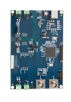 A blue printed circuit board is shown with various electronic components, including integrated circuits, capacitors, and connectors. The board features two prominent coaxial connectors at the bottom and several green terminal blocks at the top.