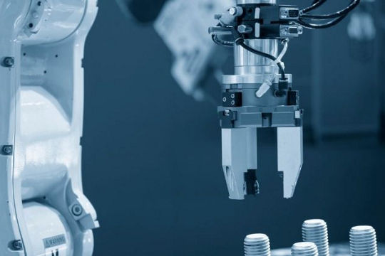 A close-up view of a robotic arm equipped with precision tools, actively working in an industrial setting.