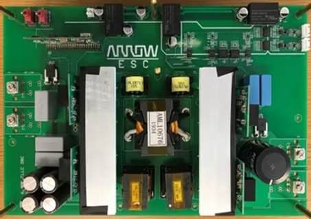 A green printed circuit board labeled 'Arrow ESC' is shown with various electronic components, including capacitors, resistors, and transformers. The board features visible metallic heat sinks, cylindrical capacitors, and blue rectangular components.