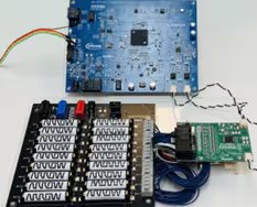 The image shows three interconnected electronic development boards on a white surface. The top board is blue and features the Altera and Intel logos, with multiple ports and a central chip. Below, a black board contains rows of labeled switches, and a smaller green board is connected with blue and black wires.