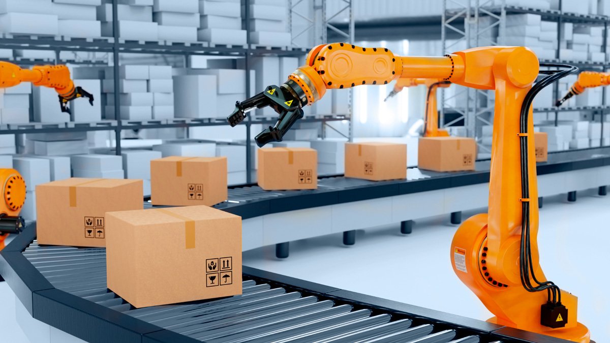 Orange robotic arms operate along a conveyor belt in a warehouse environment. 
