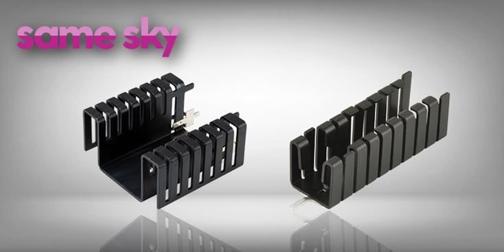 Two black cable organizers are displayed against a gradient gray background. The organizers feature a sleek, modern design with multiple slots for cable management. The text 'same sky' is visible in pink and purple in the top left corner. The image highlights the product's functionality and minimalist aesthetic.