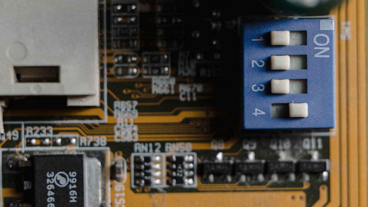 A detailed view of a circuit board featuring a blue DIP switch labeled ON and numbered 1 to 4. 