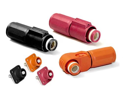 Several industrial power connectors in black, red, and orange, along with matching panel mount sockets. The connectors feature cylindrical shapes with metallic contact points and are designed for heavy-duty electrical applications. 