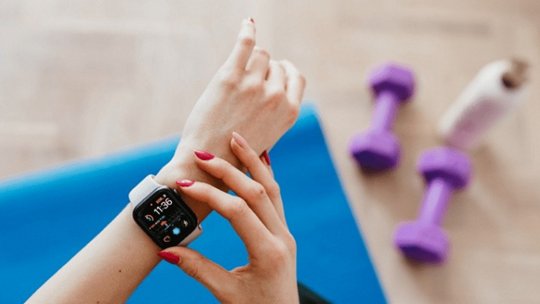 A close-up of a smartwatch displaying fitness tracking features, worn on a woman's wrist