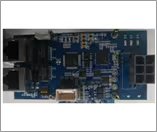 A detailed view of a blue electronic circuit board featuring multiple integrated circuits and components. Two Ethernet ports and a USB port are clearly visible on the left side, with various chips and connectors distributed across the board.