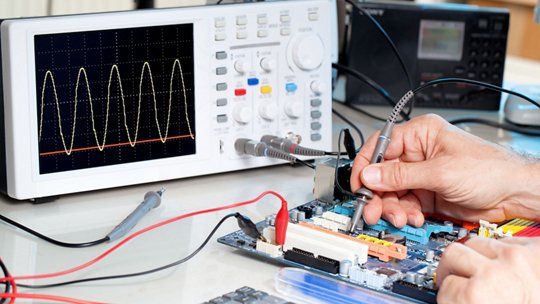 Tech tests electronic equipment in service centre.