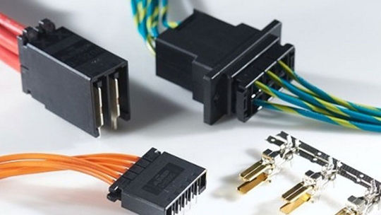 A close-up view of various electrical connectors paired with vibrant wiring in red, orange, blue, and green.