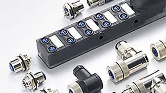 A collection of industrial connectors and a distribution block displayed on a white surface. 