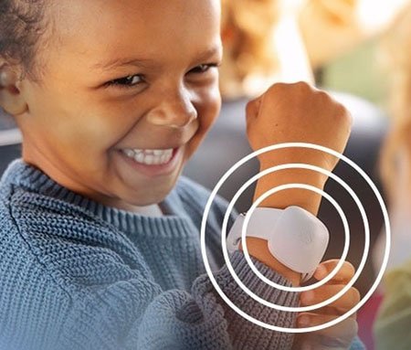 A child is shown wearing a white wearable device on their wrist, surrounded by concentric circles indicating connectivity or functionality. 