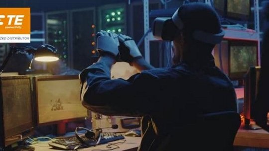 一名男子戴着虚拟现实头戴设备和手套，在一个昏暗的科技工作空间中与数字环境进行互动。