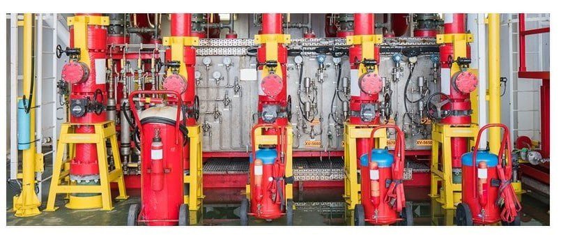 A row of red and yellow industrial fire suppression units displayed in a controlled environment
