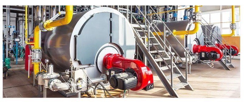 Large industrial boilers are shown in a factory setting