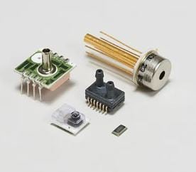 A collection of small electronic components including a circuit board, a sensor, and a microchip.
