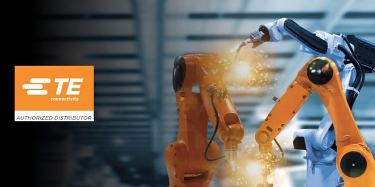 Two industrial robotic arms, one orange and one white, are shown in a factory setting performing tasks with visible sparks. 