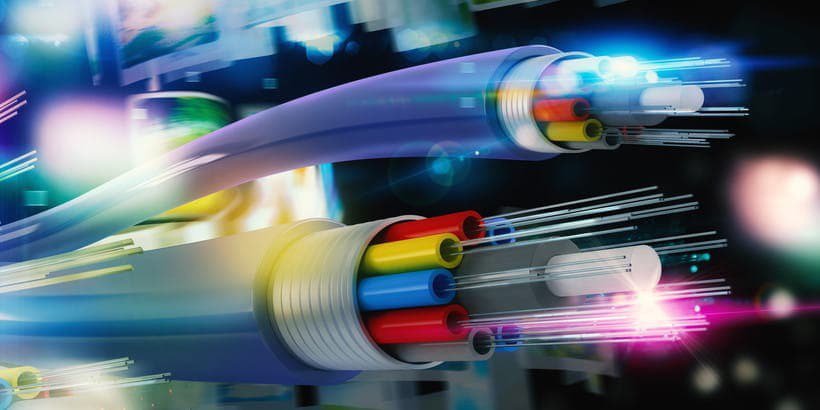 A detailed view of fiber optic cables showcasing vibrant internal wiring in red, blue, yellow, and green