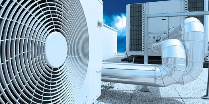 Close-up of an industrial HVAC unit featuring a large circular fan and metallic ductwork.