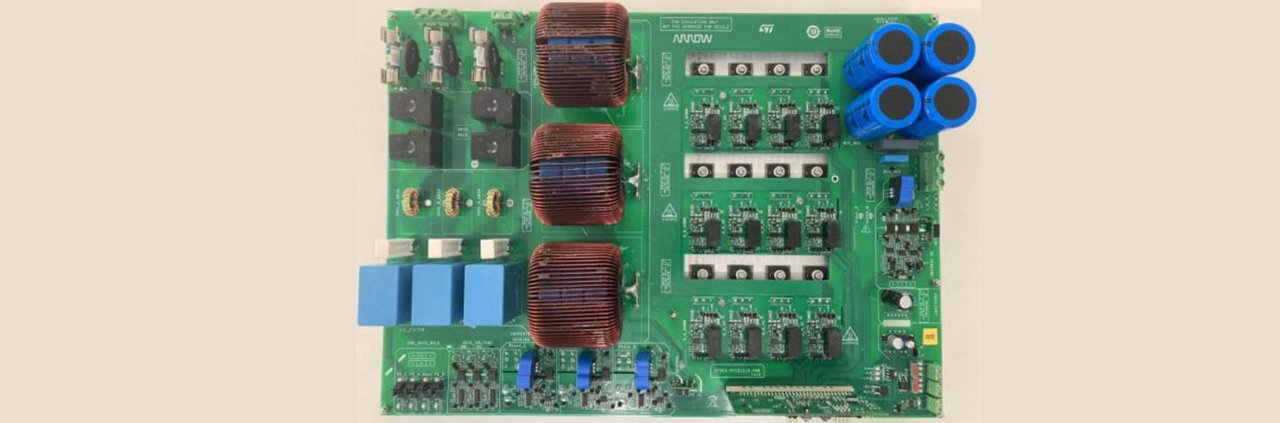 A detailed view of a green circuit board featuring multiple components, including blue capacitors and copper coils. 