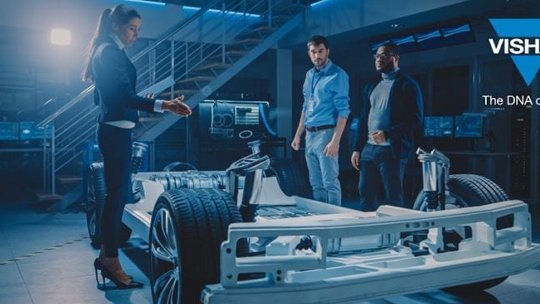 A group of engineers examines a futuristic automotive prototype in a high-tech laboratory. The setting features advanced computer screens and industrial lighting, emphasizing innovation and technology