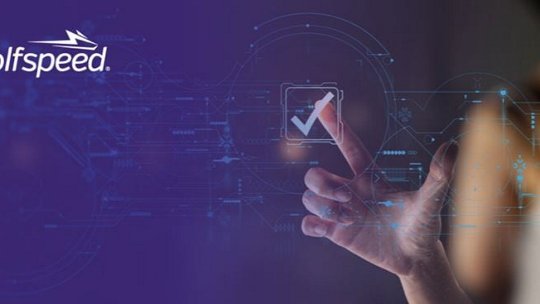 미래지향적인 디지털 인터페이스에 빛나는 체크 표시가 파란 배경 속에서 강조되고 있습니다. 왼쪽 상단에는 Wolfspeed 로고가 눈에 띄게 표시되어 있습니다. 한 손이 인터페이스와 상호작용하며 혁신과 기술을 암시합니다. 이 장면은 현대적이고 첨단 기술의 분위기를 전달합니다.
