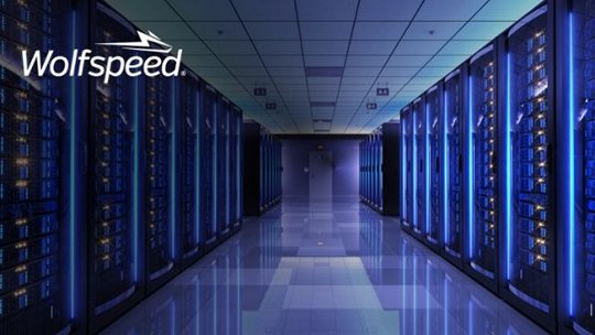 A modern data center featuring rows of illuminated server racks under blue ambient lighting. 