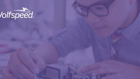 An individual is seen assembling or inspecting electronic components in a professional setting.