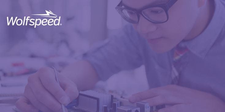 An individual is seen assembling or inspecting electronic components in a professional setting.