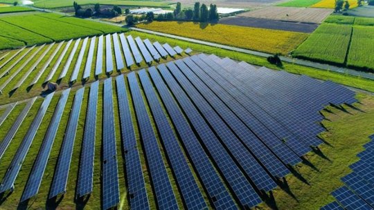 Un vasto impianto solare con file di pannelli fotovoltaici disposti in un motivo geometrico