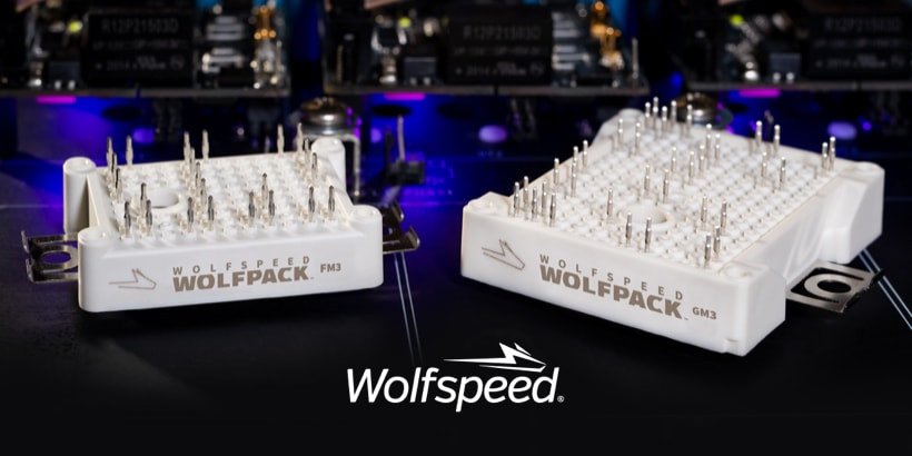 Two Wolfspeed Wolfpack power modules, PKM and GM2, are displayed in a high-tech environment with illuminated components in the background.