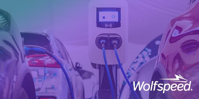 Une borne de recharge pour véhicule électrique moderne est bien en vue entre deux voitures dans un environnement propre et futuriste.