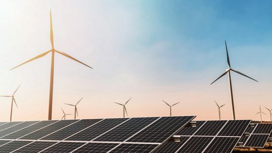 Una vista panorámica de múltiples torres de transmisión eléctrica silueteadas contra un cielo vibrante al atardecer.