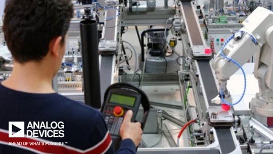 Man programming robotic arm in laboratory