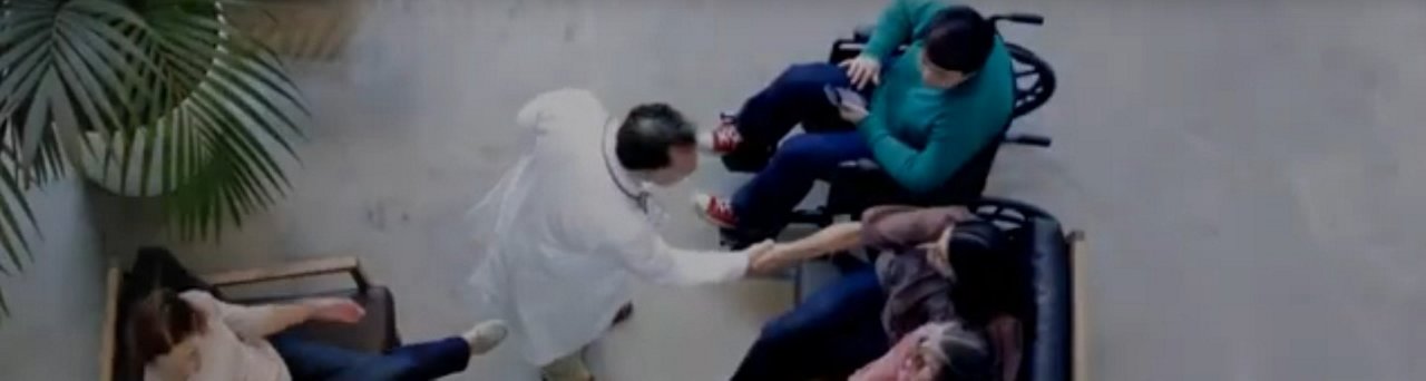 Bird eye view of physician shaking hands with a person in a busy hospital waiting room